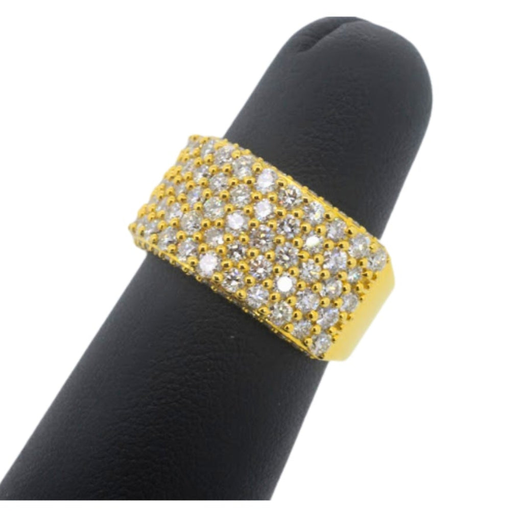 Gold ring with embedded stones on a black finger model against a white background
